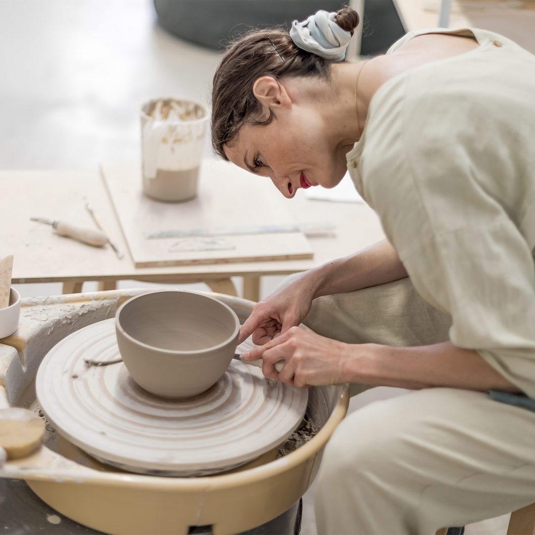 female-ceramic-artist-in-apron-working-in-pottery.jpg
